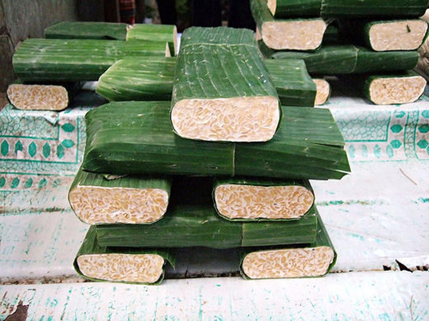 Image from Wikipedia: Traditional fresh tempeh at the market in Jakarta (Indonesia) wrapped in banana leaves