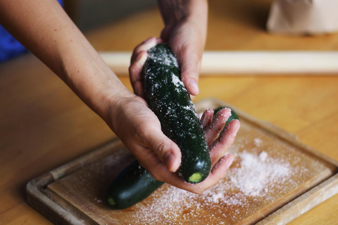 Applying salt all over the cucumber, rubbing it vigorously
