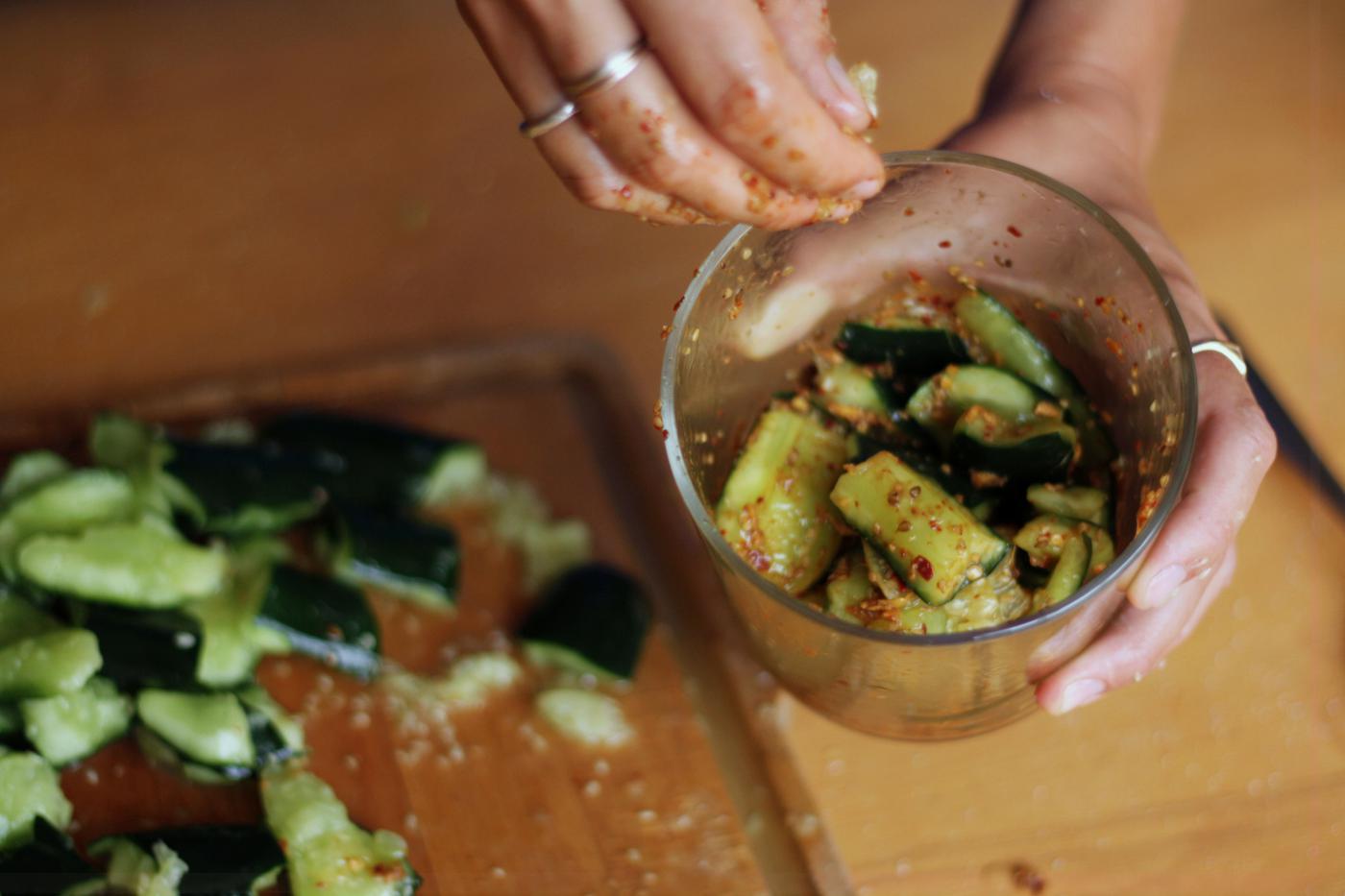 Mixing the smashed cucumber with the marinade